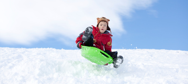 A young boy gets some air on the toboggan hill.