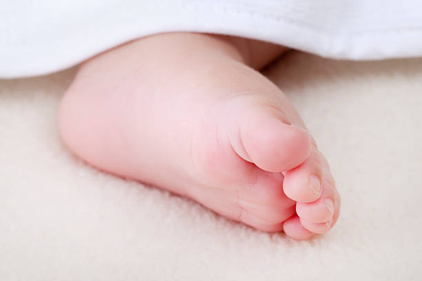 istock Newborn baby's foot peeking from below blanket (XXL) 183752005