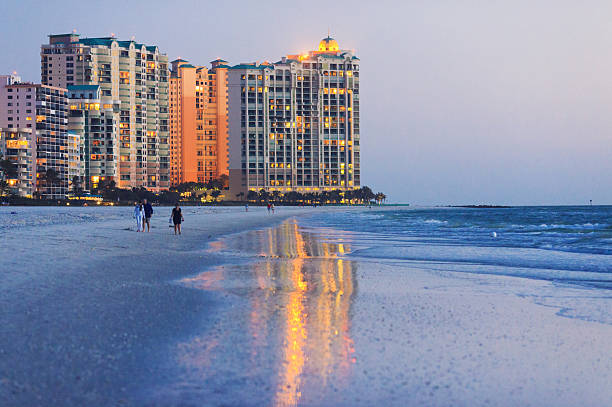 marco island beach "marco island beach ocean front building shoot at dusk, big reflection on wet sand." marco island stock pictures, royalty-free photos & images