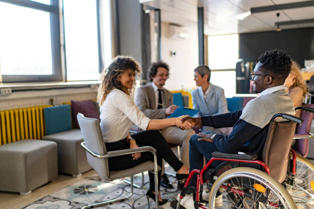istock Colleagues greeting each other while having meeting in office hall 1837526176