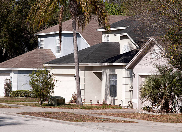 Stucco home exteriors.. The grass is dry and brown. Typical Southern California style homes.
