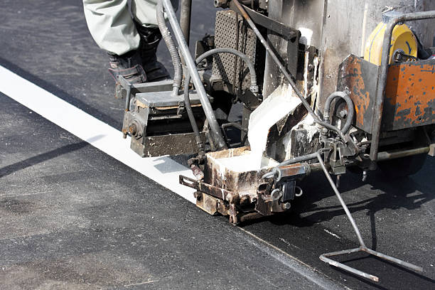 istock Road worker makes a line on new asphalt 183754430