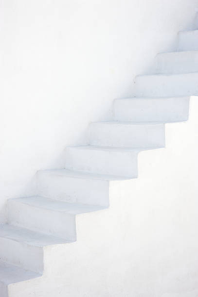 White wall of a house with a window and stairs to the second floor