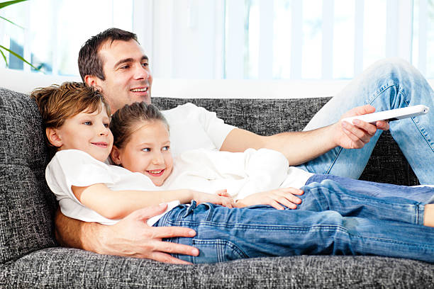 istock Father changing TV channel with his children. 183755854