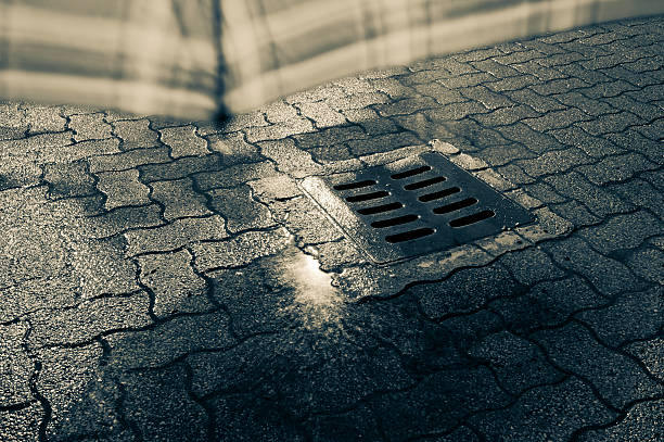 istock Manhole Under Umbrella In The Rain And Puddle 183755868