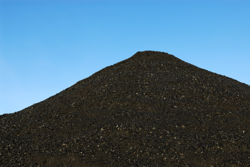 Coal mountain in front of a blue sky.Electricity