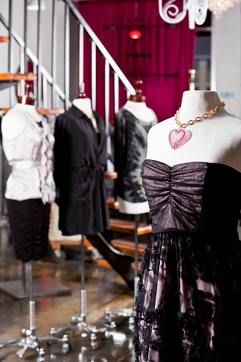 Women's fashion displayed in clothing store.  Focus on dress in foreground