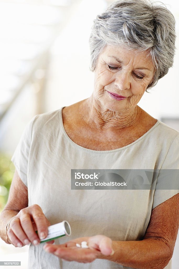 Mujer Senior con sus píldoras en mano - Foto de stock de Píldoras libre de derechos