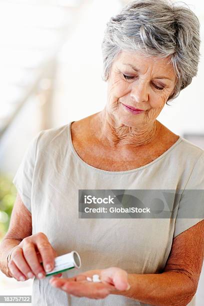 Mujer Senior Con Sus Píldoras En Mano Foto de stock y más banco de imágenes de Píldoras - Píldoras, 50-59 años, Adulto