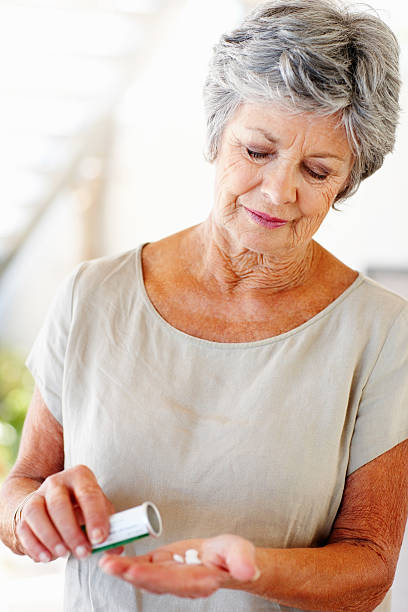istock Senior woman with pills in her hand 183757122