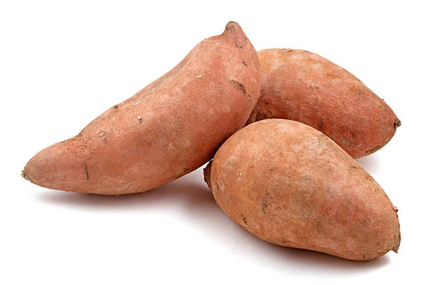 Close-up of three Raw sweet potatoes Three sweet potatoes isolated on white. sweet potato photos stock pictures, royalty-free photos & images
