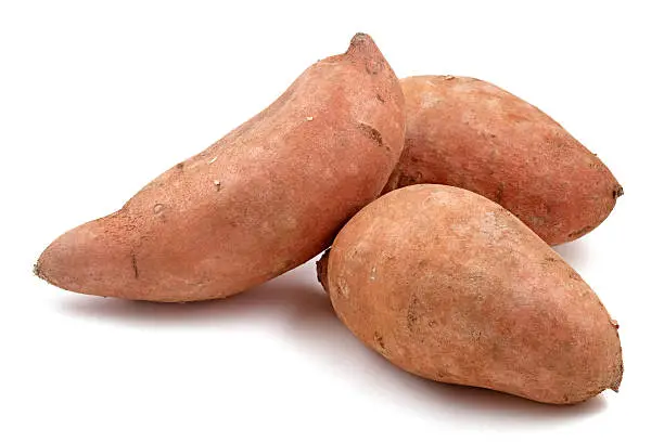 Three sweet potatoes isolated on white.