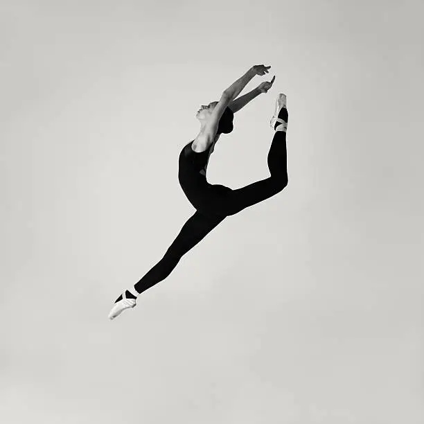 Professional modern ballet dancer jumping in studio.