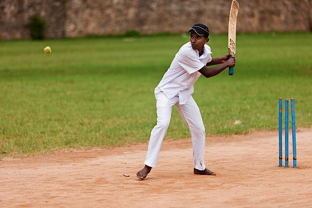 Young Sri Lankan schoolboys playing cricket Young Sri Lankan schoolboys playing cricket near Ella, Sri Lanka.http://bem.2be.pl/IS/rajasthan_380.jpg indian boy barefoot stock pictures, royalty-free photos & images
