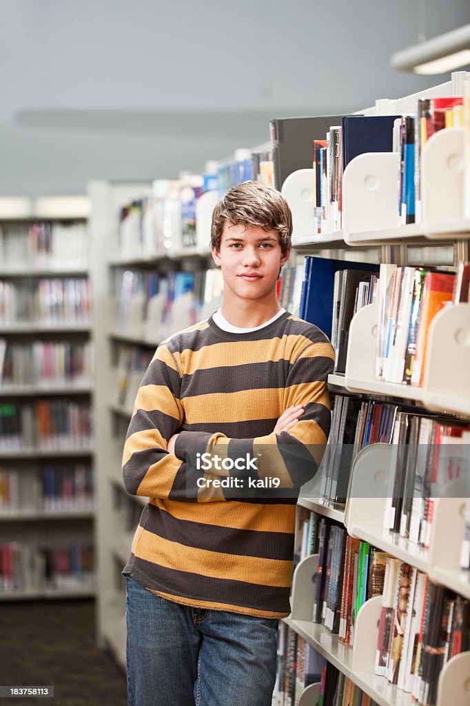 Teenage boy pie en la biblioteca - Foto de stock de Biblioteca libre de derechos