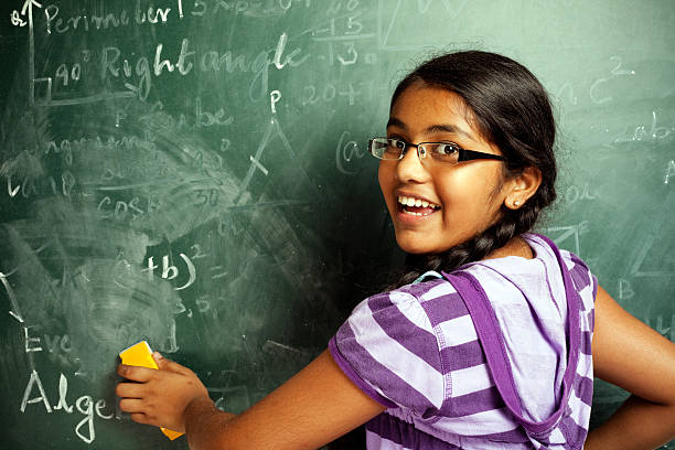 istock Cheerful Indian Girl Student Erasing Mathematics Problems from Greenboard Blackboard 183758120