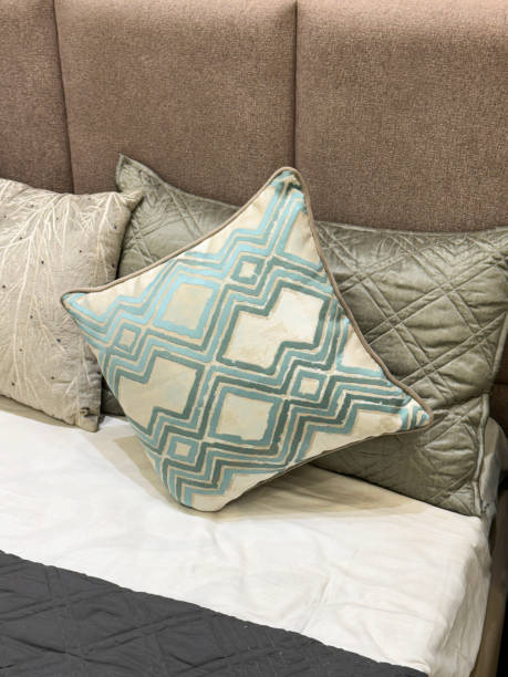 istock Full frame image of double bed with padded, material covered  headboard, quilted pillows, folded quilt cover, patterned scatter cushion, focus on foreground, elevated view 1837581728