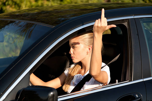 istock Young girl driver, giving middle finger insult 183758422