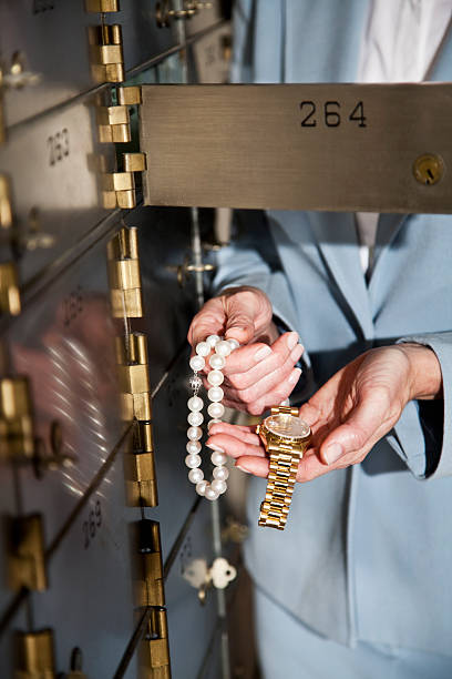 woman putting jewelry in safety deposit box - 銀行保管箱 個照片及圖片檔