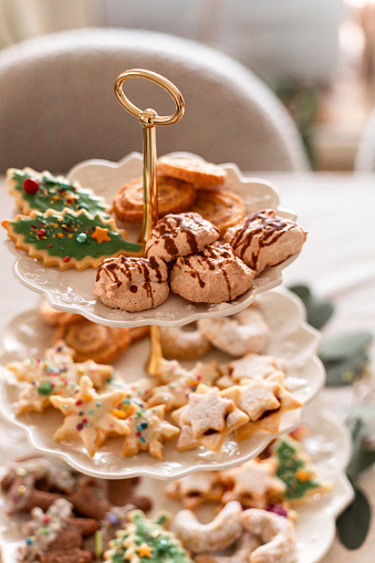 Homemade Christmas cookies in cozy kitchen with variety of biscuits and cookies served on cake stand