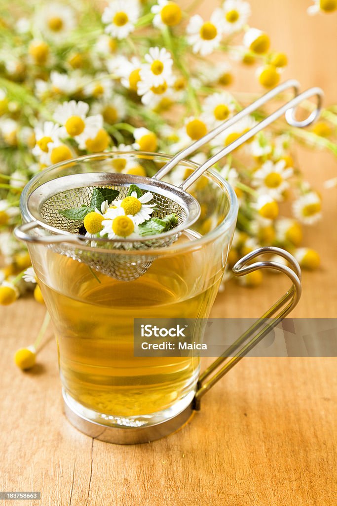 Chamomile tea infusion Chamomile tea infusion on a freshly haversted chamomile flowers background.More at Natural Herbs Lightbox: Chamomile Stock Photo