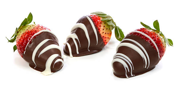 Chocolate dipped strawberries 3 strawberries dipped in dark chocolate with white chocolate drizzle on white background chocolate covered strawberries stock pictures, royalty-free photos & images
