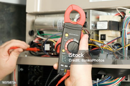 istock Repairman Checks Voltage on Geothermal HVAC System 183758726