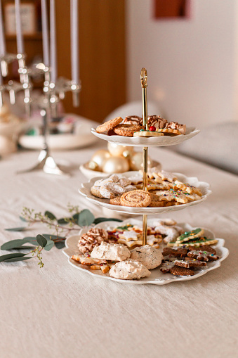 Homemade Christmas cookies in cozy kitchen with variety of biscuits and cookies served on cake stand