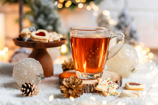 Cup of tea with homemade Christmas cookies in cozy kitchen with Christmas decorations