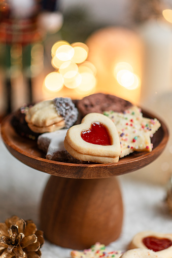 Christmas chocolate cookies on wooden table with tea, balls and defocused lights