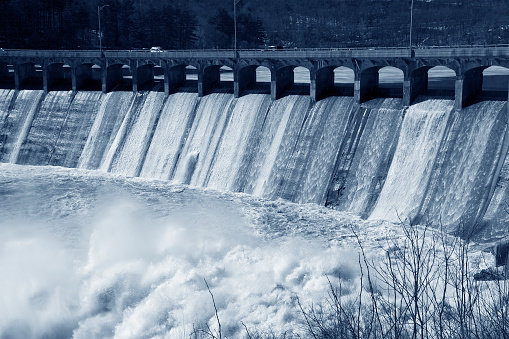 heavy rains and melting snow cause water to pour over a hydroelectric dam causing major flooding down river.