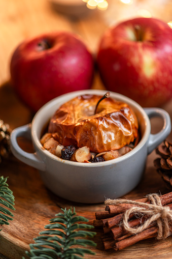 Baked Apple dessert with Nuts and cinnamon on cozy Christmas table at Christmas market