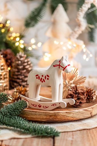 Traditional Christmas present rocking horse toy made of wood on festive Christmas table