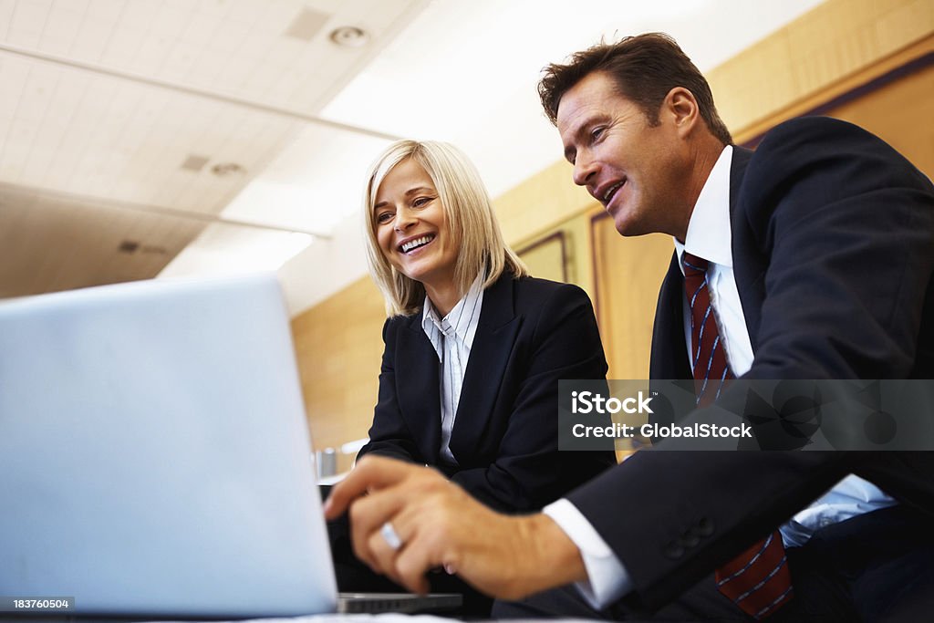 Man presenting business ideas to woman on laptop Happy business man and woman working together on a laptop 40-49 Years Stock Photo