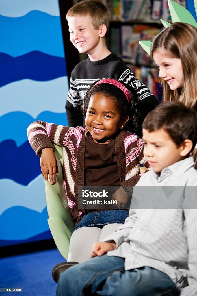Diverse group of young children in library Multiracial children, 6 to 8 years, in school library.  Focus on African American girl 6-7 Years Stock Photo