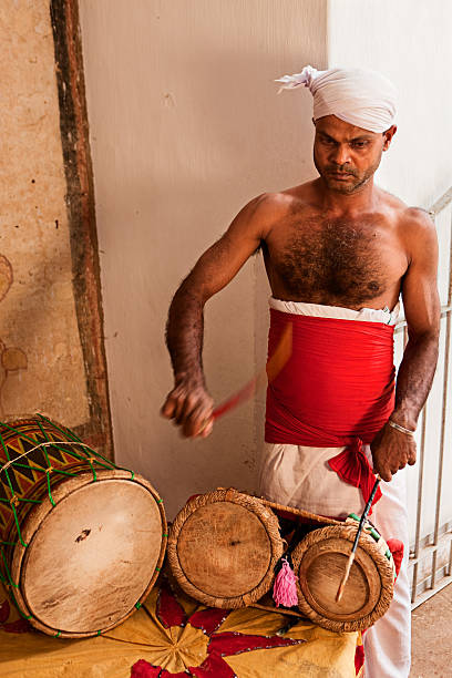 istock Man wearing traditional Sri Lankan Costume playing drums inside temple 183761379