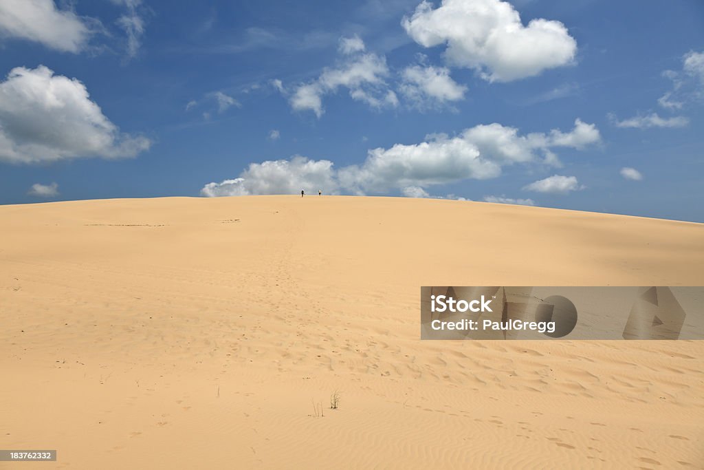 Sandunes in Mozambique. Two hikers on a sandune in the Bazaruto archipelago Mozambique. These sand dunes are created but millions of years of sand washed into the sea from the Limpopo river and sand forms most of the islands in this region.Here are similar images. Benguerra Island Stock Photo