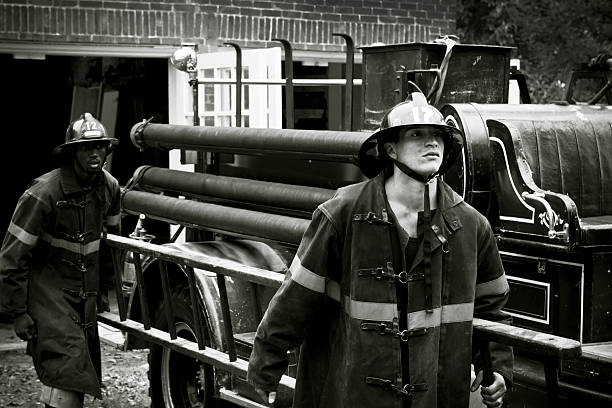 istock Vintage Firefighters Carrying A Ladder 183762345