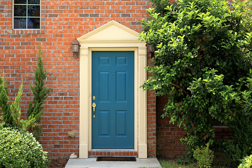 close up wooden door from a brick house.