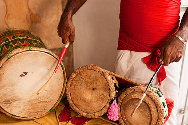 istock Man wearing traditional Sri Lankan Costume playing drums inside temple 183763637