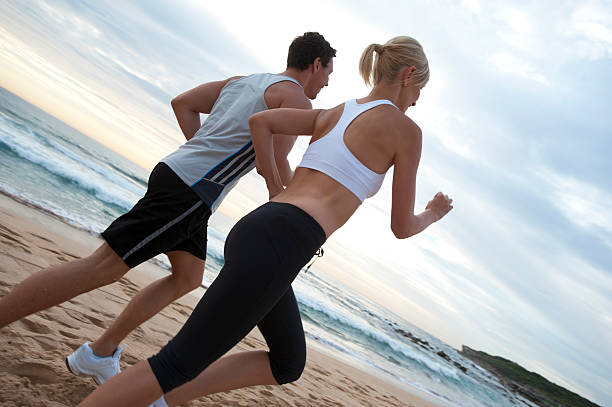 couple de jogging - shorts rear view summer beach photos et images de collection