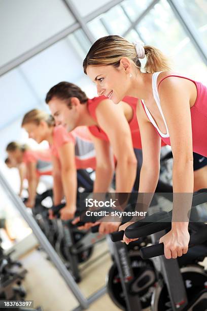 Young People Training On Exercise Bike At The Gym Stock Photo - Download Image Now - Exercising, Red, Gym
