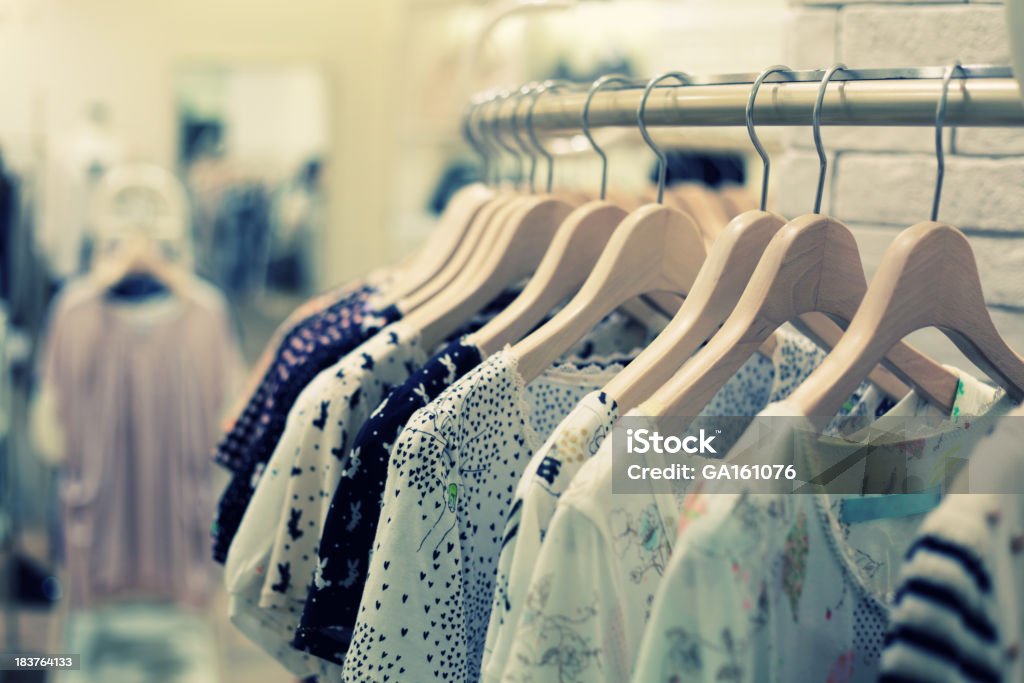 Retail Shopping Sale - Clothing in Fashion Store Close-up of color shirts hanging on the rack. Clothing Stock Photo