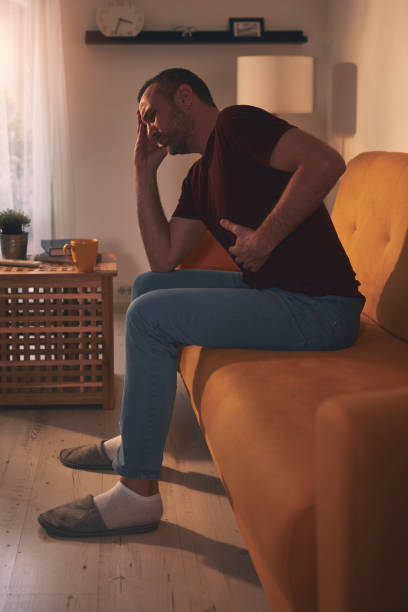 istock Man with stomach and head pain at home. 1837646494