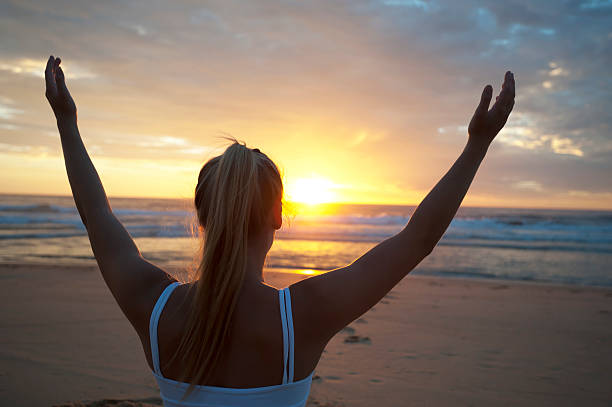 istock Woman doing yoga on the beach 183764954
