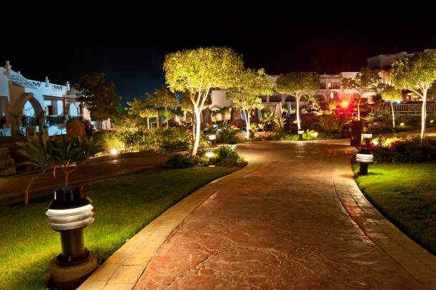 Hotel path illuminated by red light Long exposure hotel resort shot. Road around hotel landscape lighting stock pictures, royalty-free photos & images