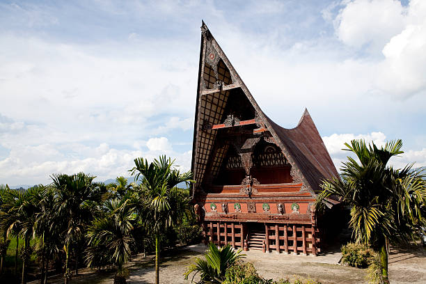 lake toba batak house "Batak architecture refers to the related architectural traditions and designs of the various Batak peoples of North Sumatra, Indonesia. Batak houses are boat-shaped with intricately carved gables and upsweeping roof ridges." danau toba lake stock pictures, royalty-free photos & images
