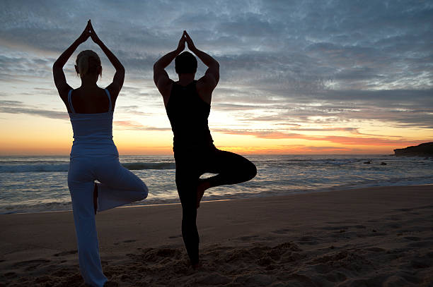 istock Couple on beach at sunset  in yoga position 183765436