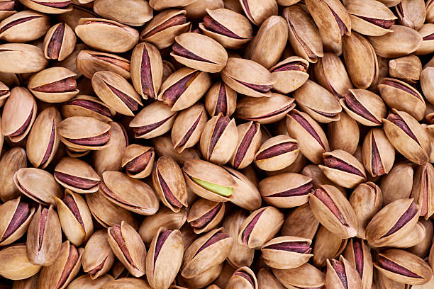 Pistachios in shell "Gaziantep pistachios (Antep fAstAA) in shell as a background. The kernels are often eaten whole, either fresh or roasted and salted, and are also used in ice cream and confections such as baklava. Full frame.Nobody." gaziantep city stock pictures, royalty-free photos & images