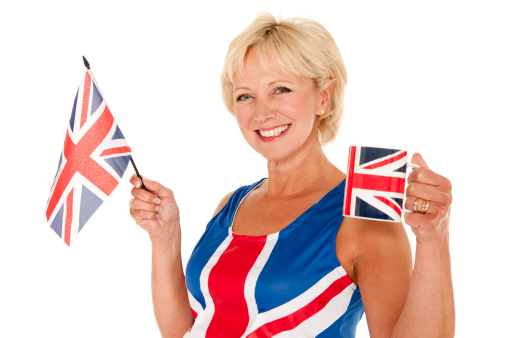 Mature British woman in Union Jack outfit with flag and mug of tea
